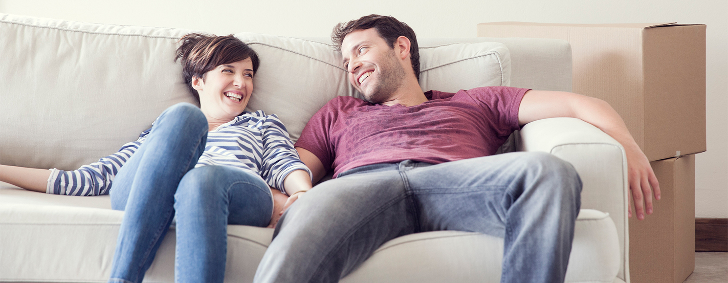 couples  smiling at each other sitting in a couch
