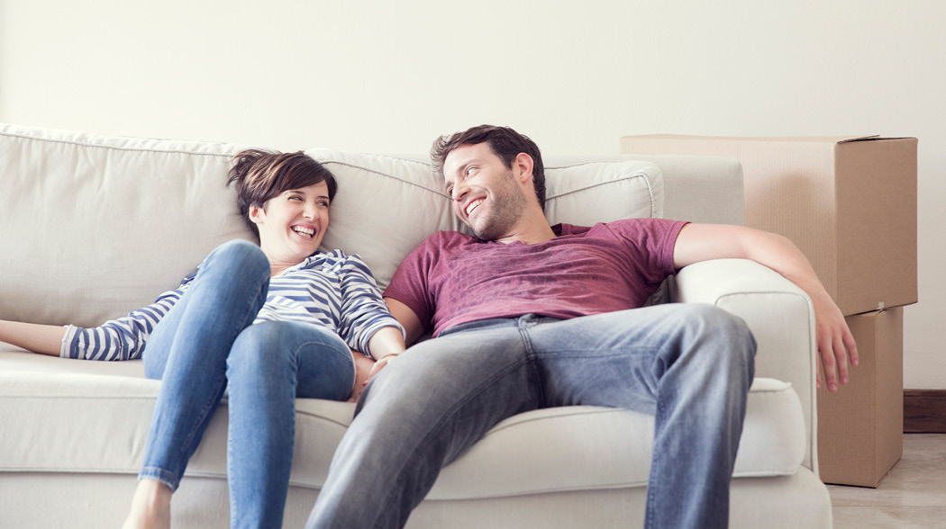 couples  smiling at each other sitting in a couch